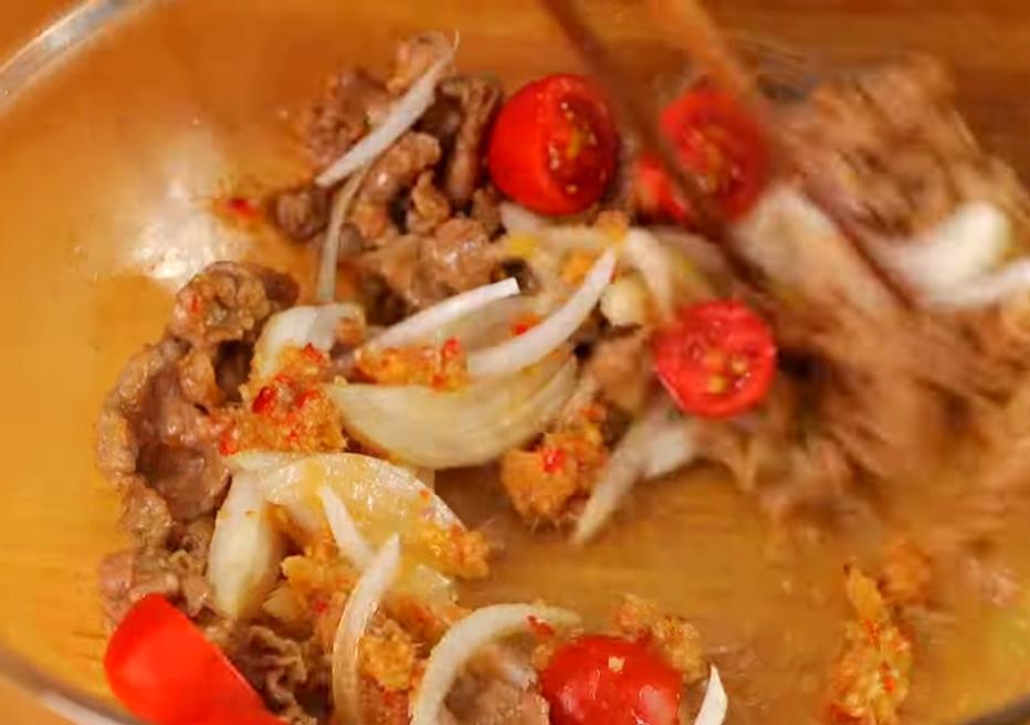 豬肉片與洋蔥、切半番茄混和，加入醬汁拌勻，放上香菜裝飾即完成。