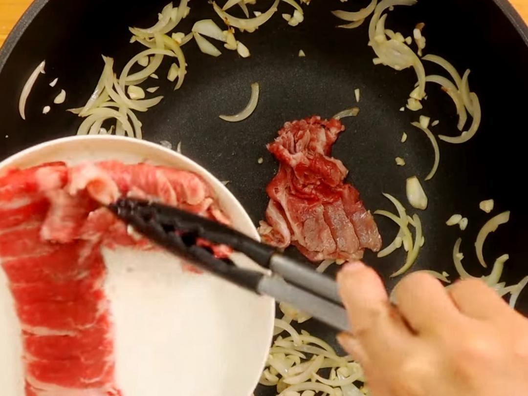 熱鍋，下少許油，將洋蔥炒軟後爆香蒜末，接著放入火鍋肉片炒香。