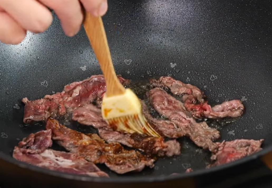 取平底鍋下牛肉，煎至5分熟時將兩面刷上醬汁。