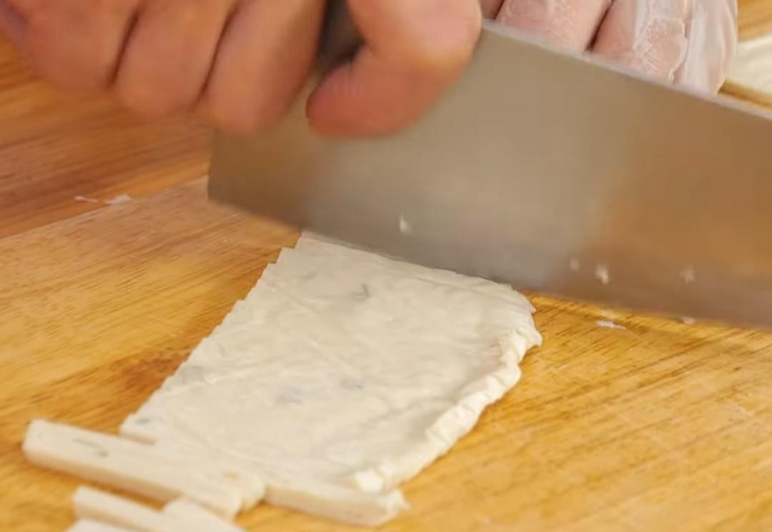 先將抓餅對半切開,再分切成寬約2公分的條狀。