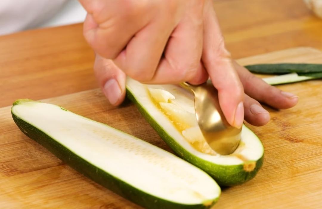 櫛瓜洗淨後直切剖半，挖出中間籽肉的部分備用，挖成一個淺槽。