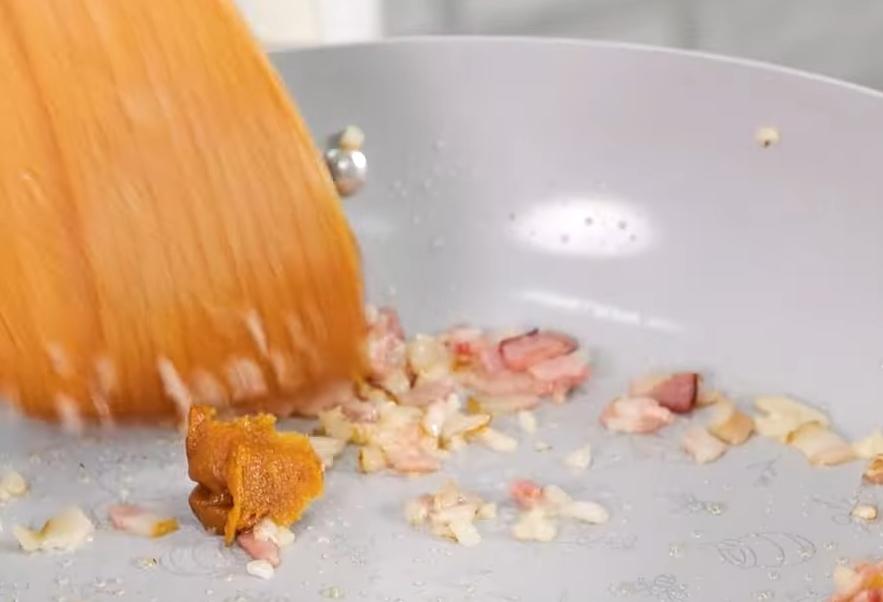 平底鍋下少許油，炒香洋蔥末、蒜末，加入培根炒至金黃，再加入味噌拌勻。