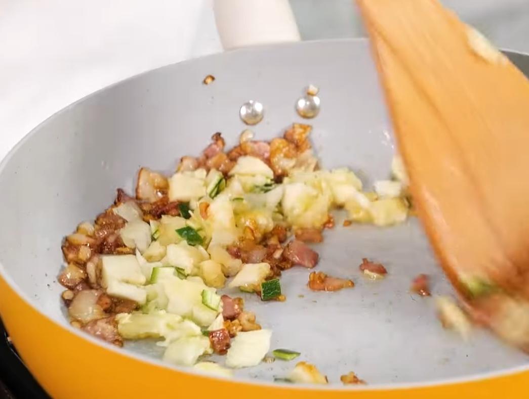 拌入櫛瓜籽肉的部分，以醬油、味醂、糖拌勻調味，再加一點起司絲煮融後，將餡料均勻鋪在櫛瓜淺槽內，上面再撒一層起司絲。