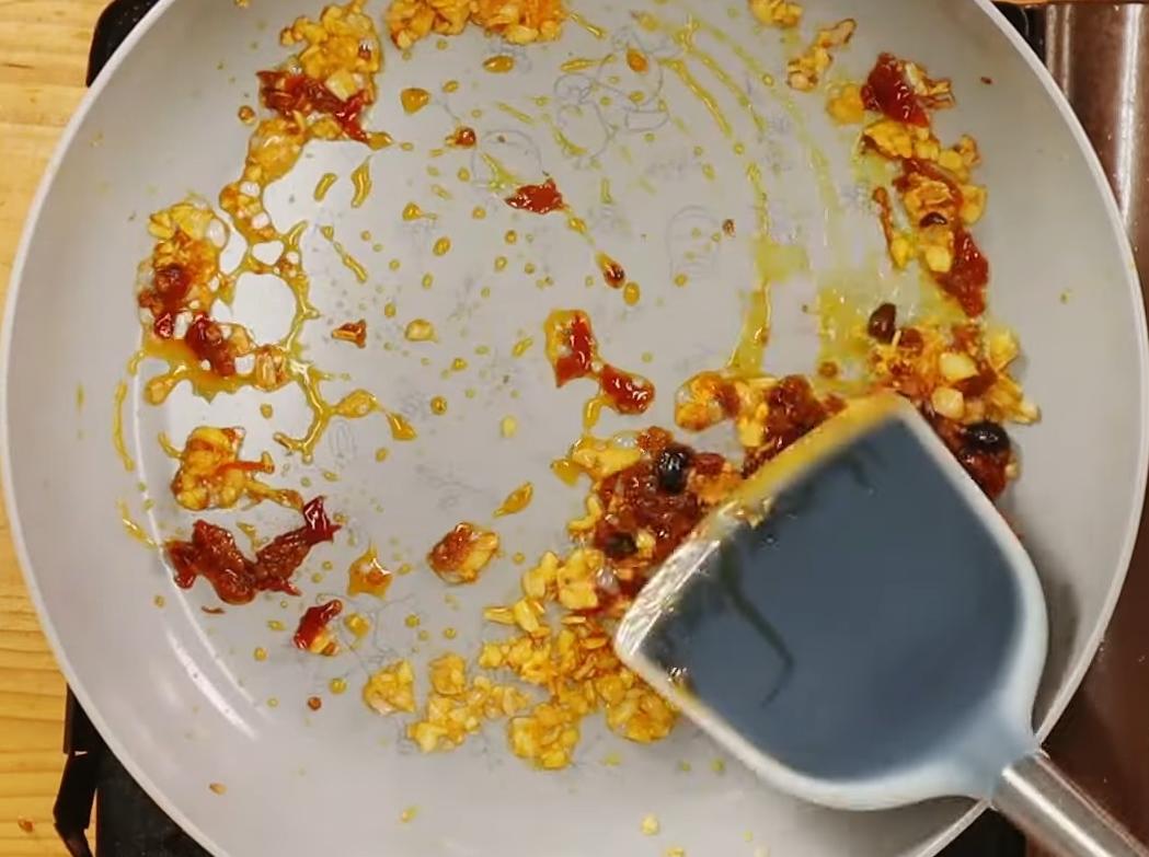 取炒鍋加入辣拌醬的油來炒香蒜頭、紅蔥頭，再加入辣拌醬拌炒，取出放涼。