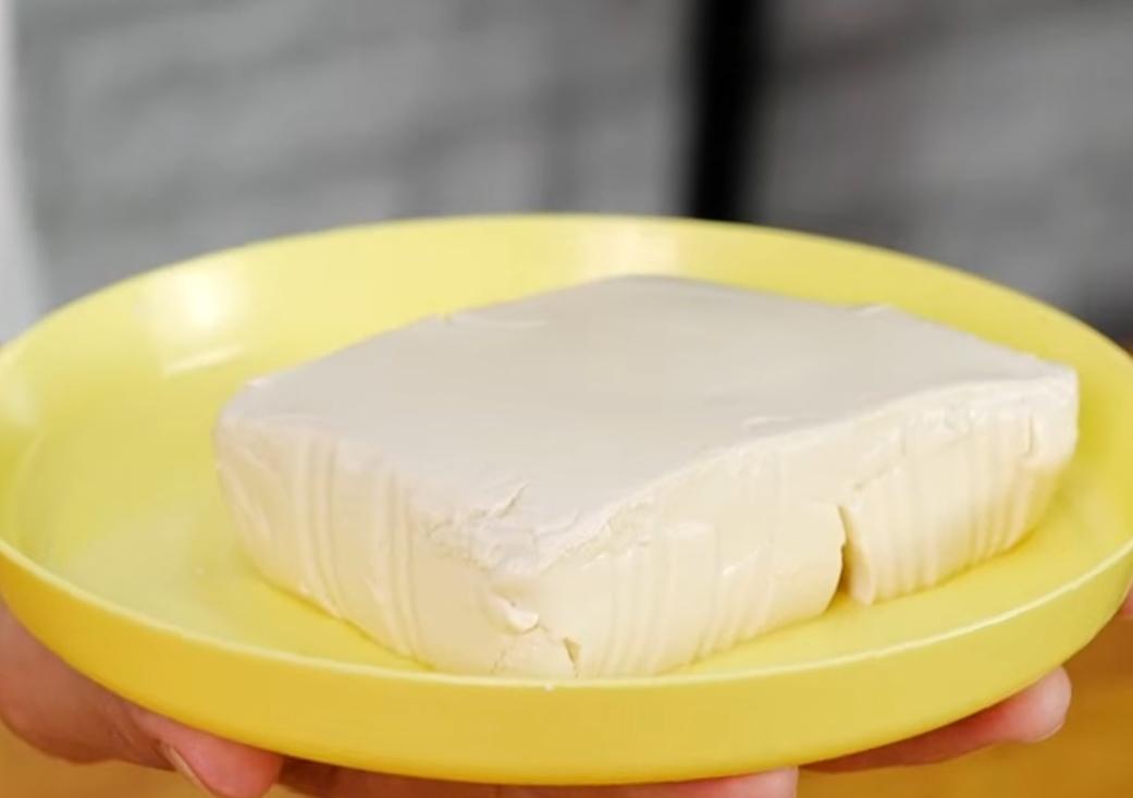 取廚房紙巾包覆住嫩豆腐，上面壓上大碗或平盤，讓豆腐多餘的水份釋出，可多次更換紙巾吸乾水分。