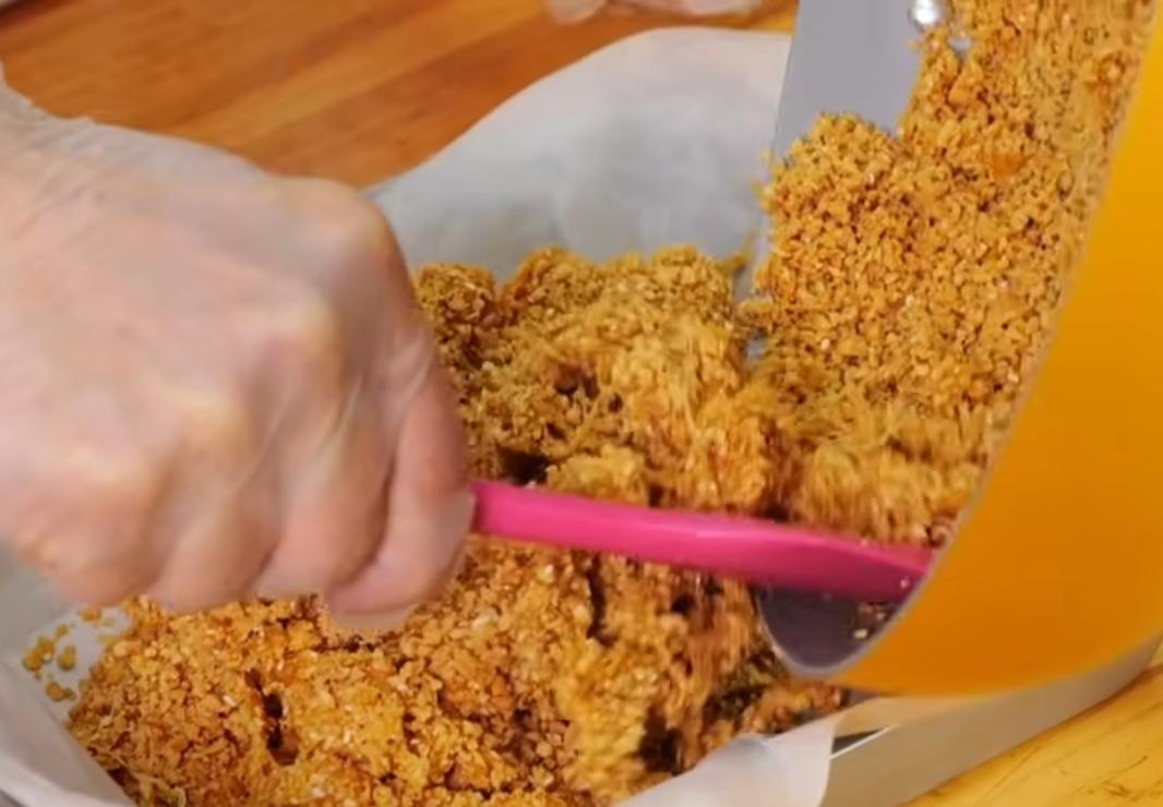 將打好的花生芝麻粉倒入並趁熱快速拌勻，接著倒入鋪有烘焙紙的烤盤中，再快速整形壓緊實，趁溫熱時切成小塊狀，待涼定型即可。