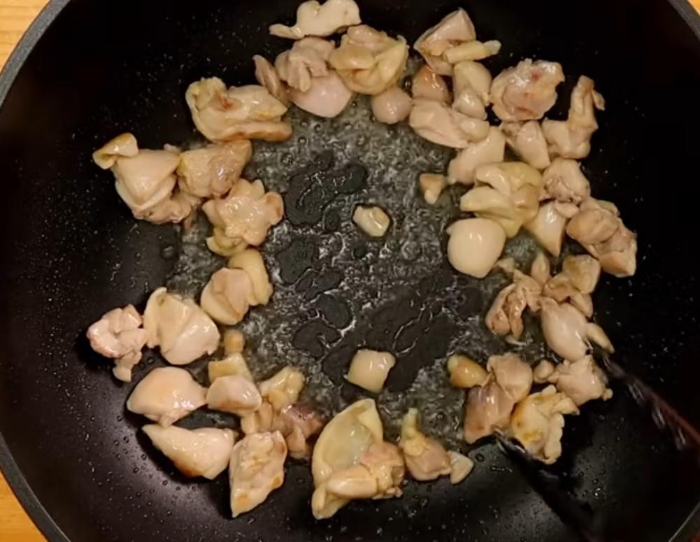 雞腿切小塊並擦乾表面水分，熱鍋冷油下雞腿，將皮面煎至金黃。