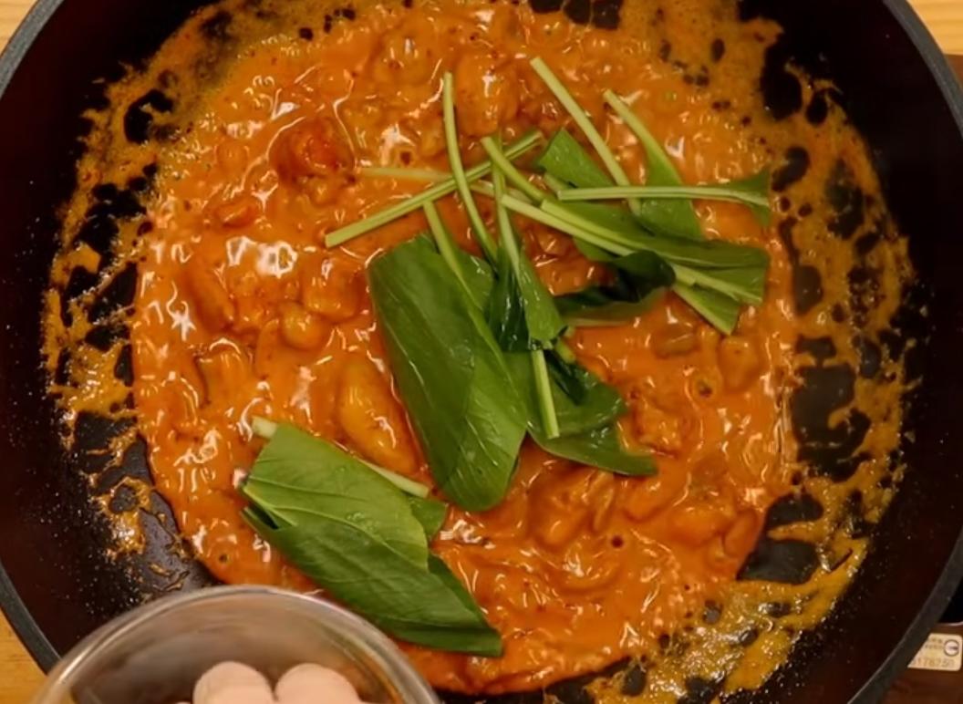 略煮至鮮奶油乳化後接著加入油菜葉，拌煮至滾即可起鍋，澆淋在白飯上即完成。
