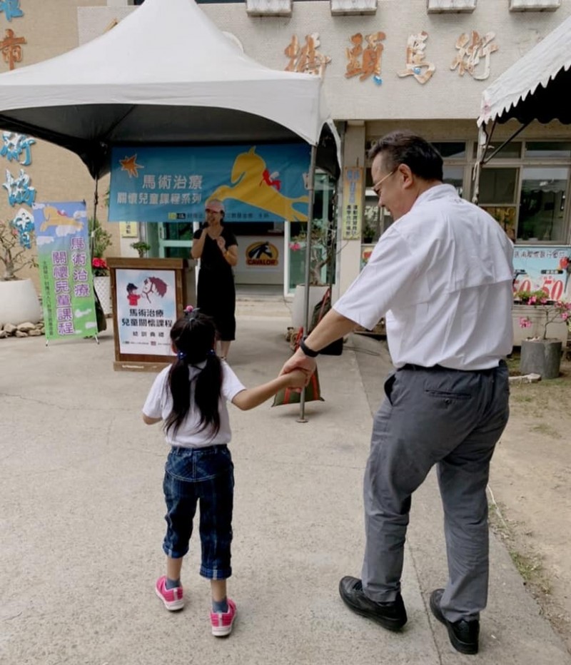 第15屆小學員芯芯，緊握余政憲的手，象徵希望，走向不一樣的未來。（記者洪定宏翻攝）