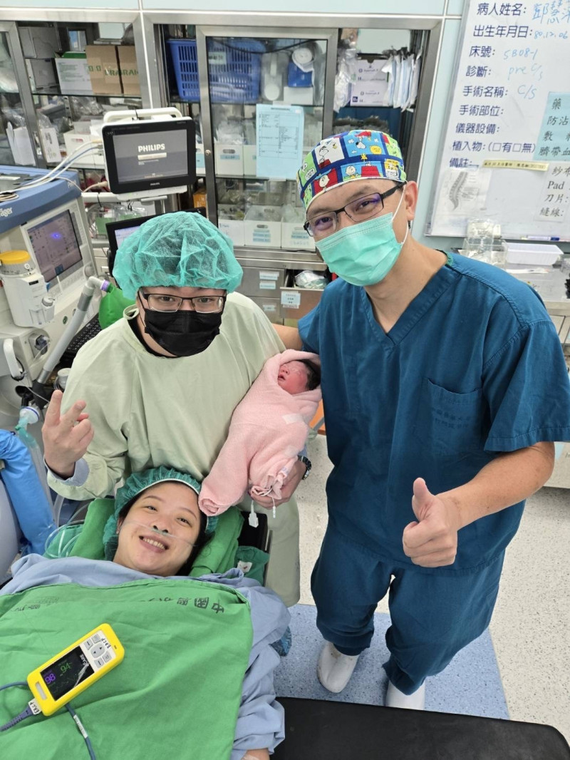 中醫大新竹附醫婦產科醫師吳秉忠（中）跟圖左下的女寶媽合作，歷經胎內手術、安胎等過程，今天終於歡喜剖腹迎出圖中這個一度可能不保的小女嬰成國慶寶貝。（中醫大新竹附醫提供）