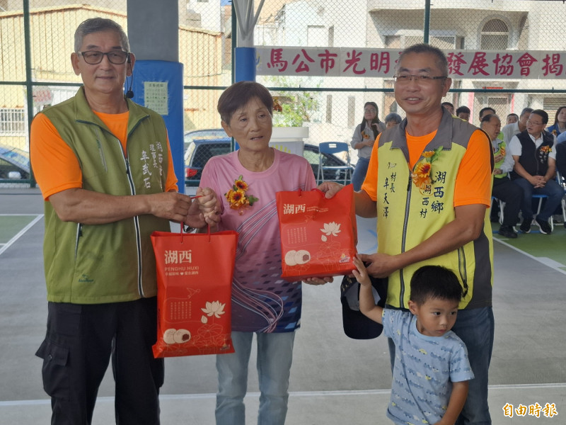光明里長黃敏惠為光明女兒、湖西媳婦,湖西村長、社區理事長致贈炸棗。(記者劉禹慶攝) 光明里長黃敏惠為光明女兒、湖西媳婦,湖西村長、社區理事長致贈炸棗。(記者劉禹慶攝)