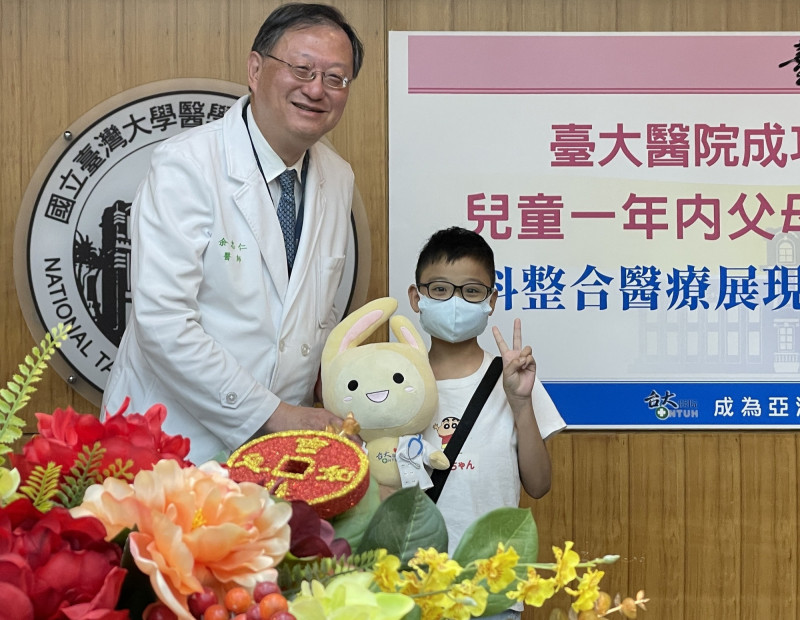台大醫院院長余忠仁（左）致贈台大醫院吉祥物「醫寶」給許小弟做紀念。（記者羅碧攝）