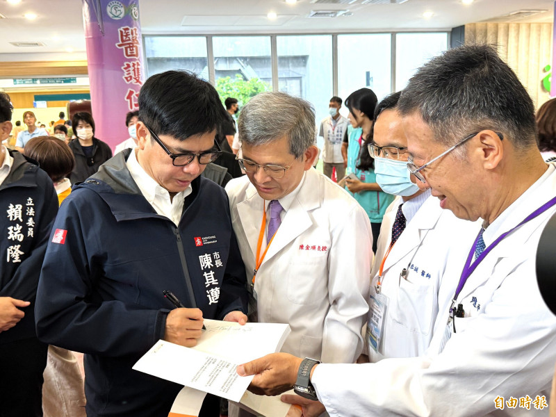 高雄榮總院長陳金順(中)、高市聯醫前院長馬光遠(右)等,拿著「陳其邁緊緊緊」一書給陳其邁(左)簽名。(記者許麗娟攝) 高雄榮總院長陳金順(中)、高市聯醫前院長馬光遠(右)等,拿著「陳其邁緊緊緊」一書給陳其邁(左)簽名。(記者許麗娟攝)