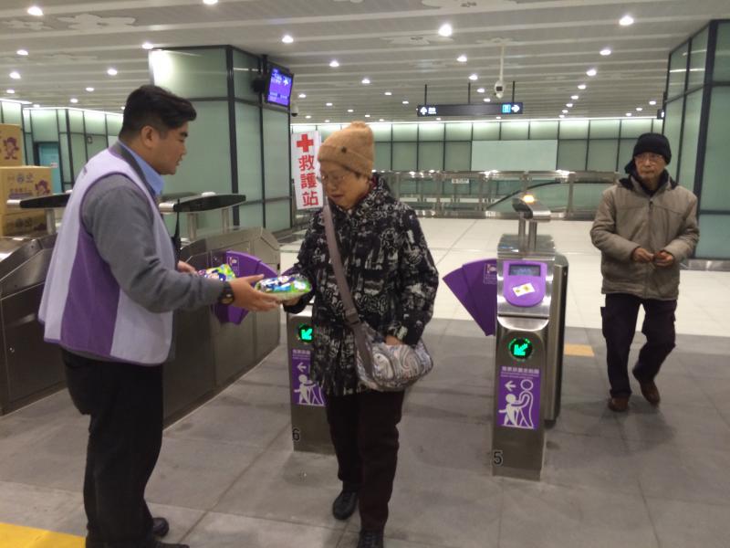 為慶祝機場捷運線通車，今日站務人員於出口處發送通車禮「乖乖通車紀念限量包」。(記者李容萍攝)