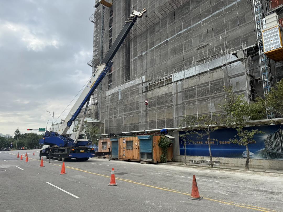 工地違法將貨櫃佔用人行空間，被要求吊離現場。（桃園市建管處提供）