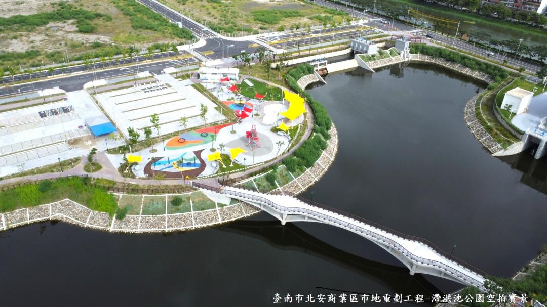 「臺南市北安商業區市地重劃工程」於設計上考量各年齡層的使用需求，打造安南區第一座全齡共享、多元使用的綠意特色公園，工程也導入綠色永續概念，設置容量6.4萬立方公尺的滯洪池與建構18cms抽水站，強化周邊152公頃土地的防洪能力。(圖:南市府地政局提供)