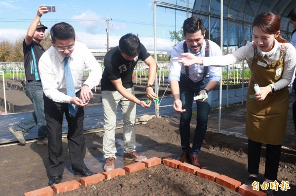 宜蘭市長江聰淵（左）在智慧農園，撒下種子，打造「英式花園」。（記者林敬倫攝）