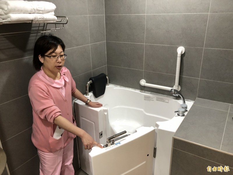 護理長何秋霞介紹身障房的浴缸，可以打開側門進入，顯得相當貼心。（記者謝武雄攝）