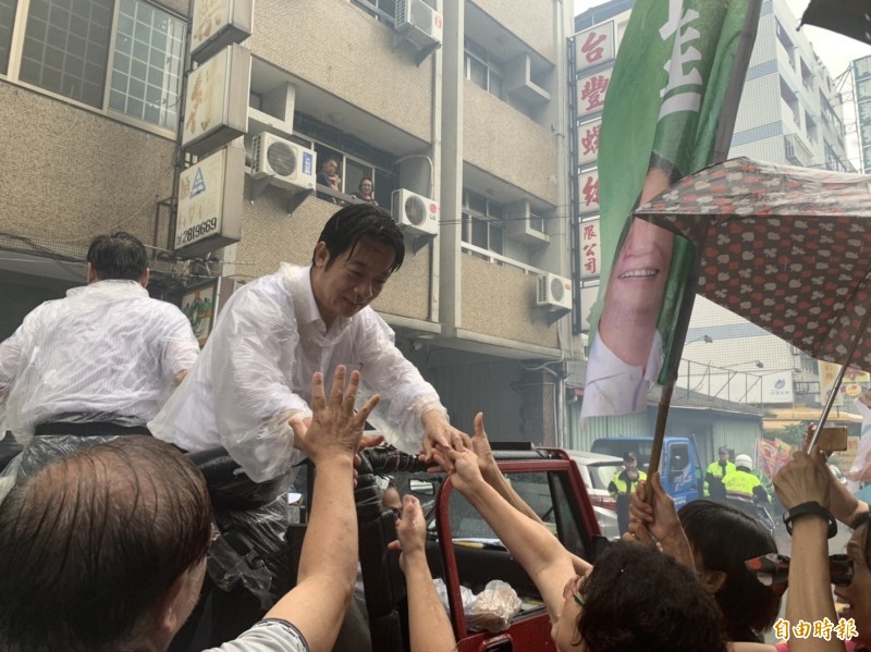 賴清德冒雨赴台中市東區掃街，支持者紛紛湧上握手。（記者張瑞楨攝）