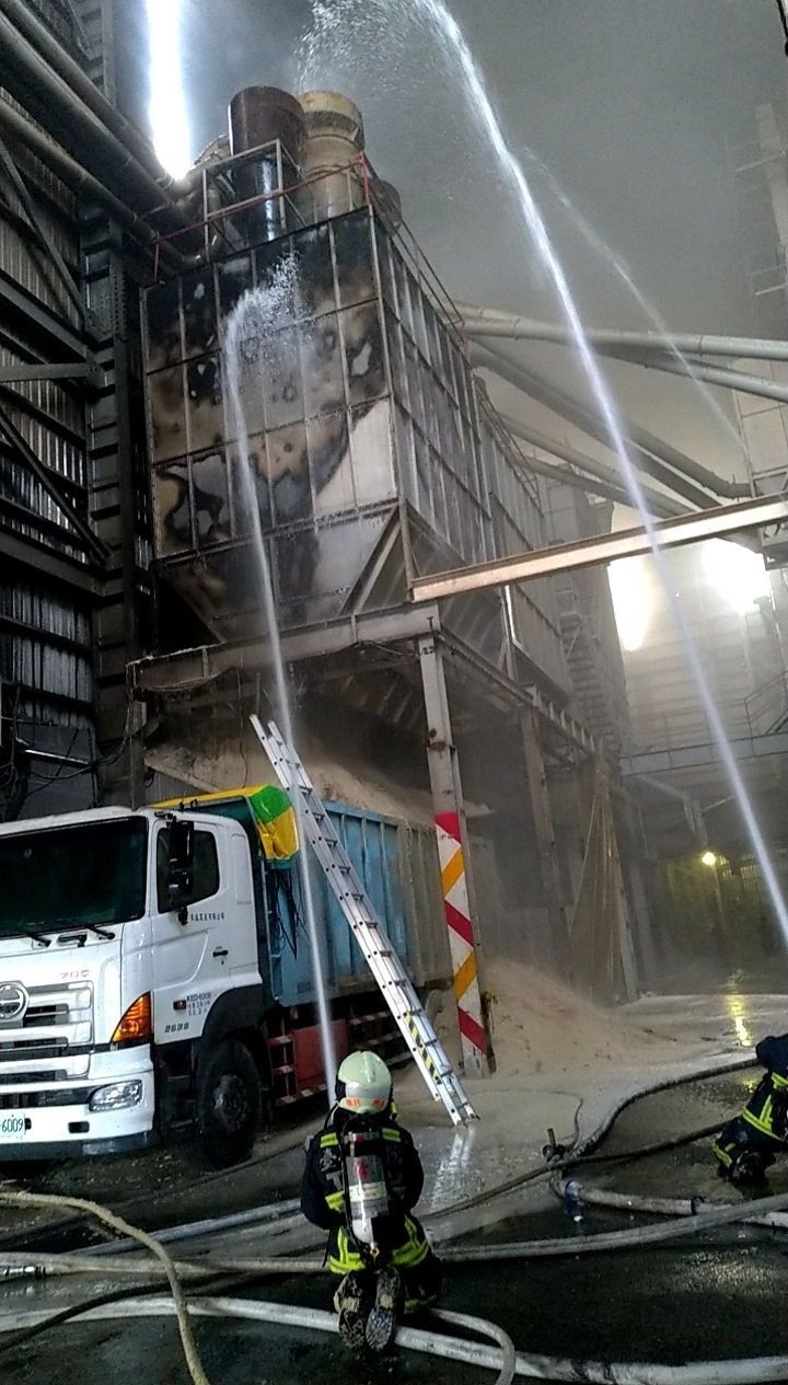 台中龍井中央路2段的源豐碾米廠，今天傍晚5點多時米糠儲存槽起火燃燒，消防人員全力出水搶救撲滅火勢。（記者陳建志翻攝）
