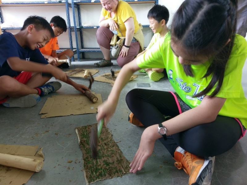 學生們拿鐵槌敲打構樹使之變成一片構樹皮。（記者王俊忠翻攝）