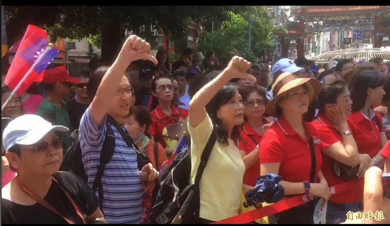 國民黨總統參選人韓國瑜到桃園景福宮參香，韓未到場前，一名來自中國的男遊客與妻子狂比「倒讚」手勢。（記者謝武雄攝）