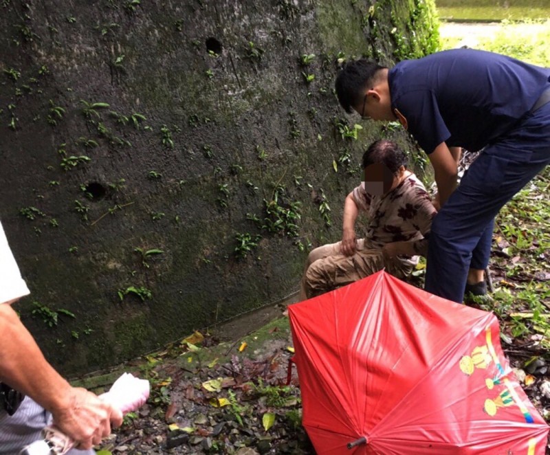 員警發現何婦坐在山溝，全身濕透。（記者歐素美翻攝）