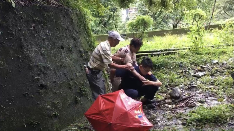 員警背起迷途的何婦，坐上巡邏車返回飯店。（記者歐素美翻攝）