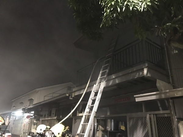 起火處為2樓鐵皮建築物，消防員架梯、佈水線灌救。（記者丁偉杰翻攝）
