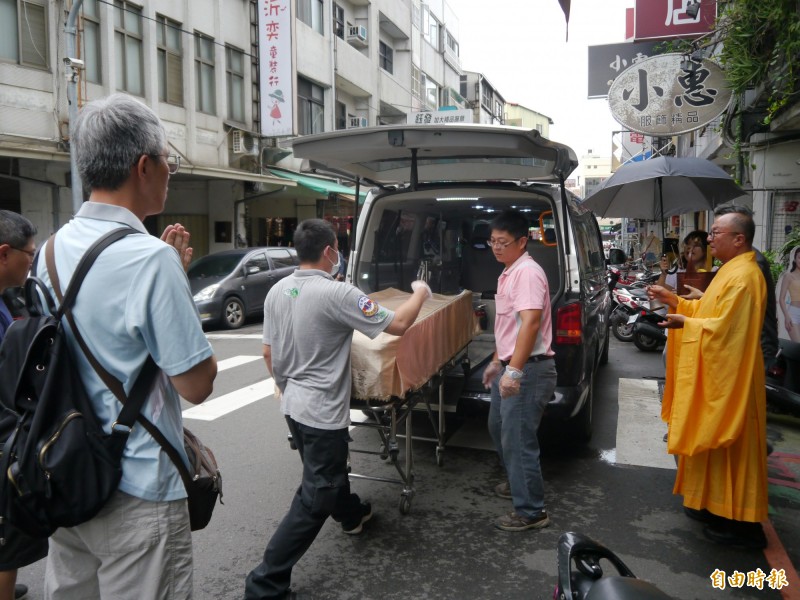 葬儀社人員將老婦遺體送至殯儀館。（記者張軒哲攝）