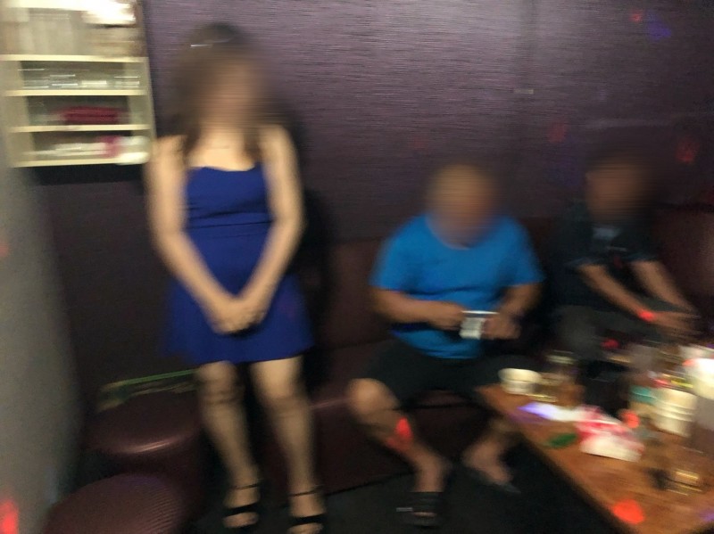 越南妹（左）坐檯陪酒，脫得精光，見基隆市聯合稽查小組人員臨檢，才趕緊穿上連身衣裙。（記者林嘉東翻攝）