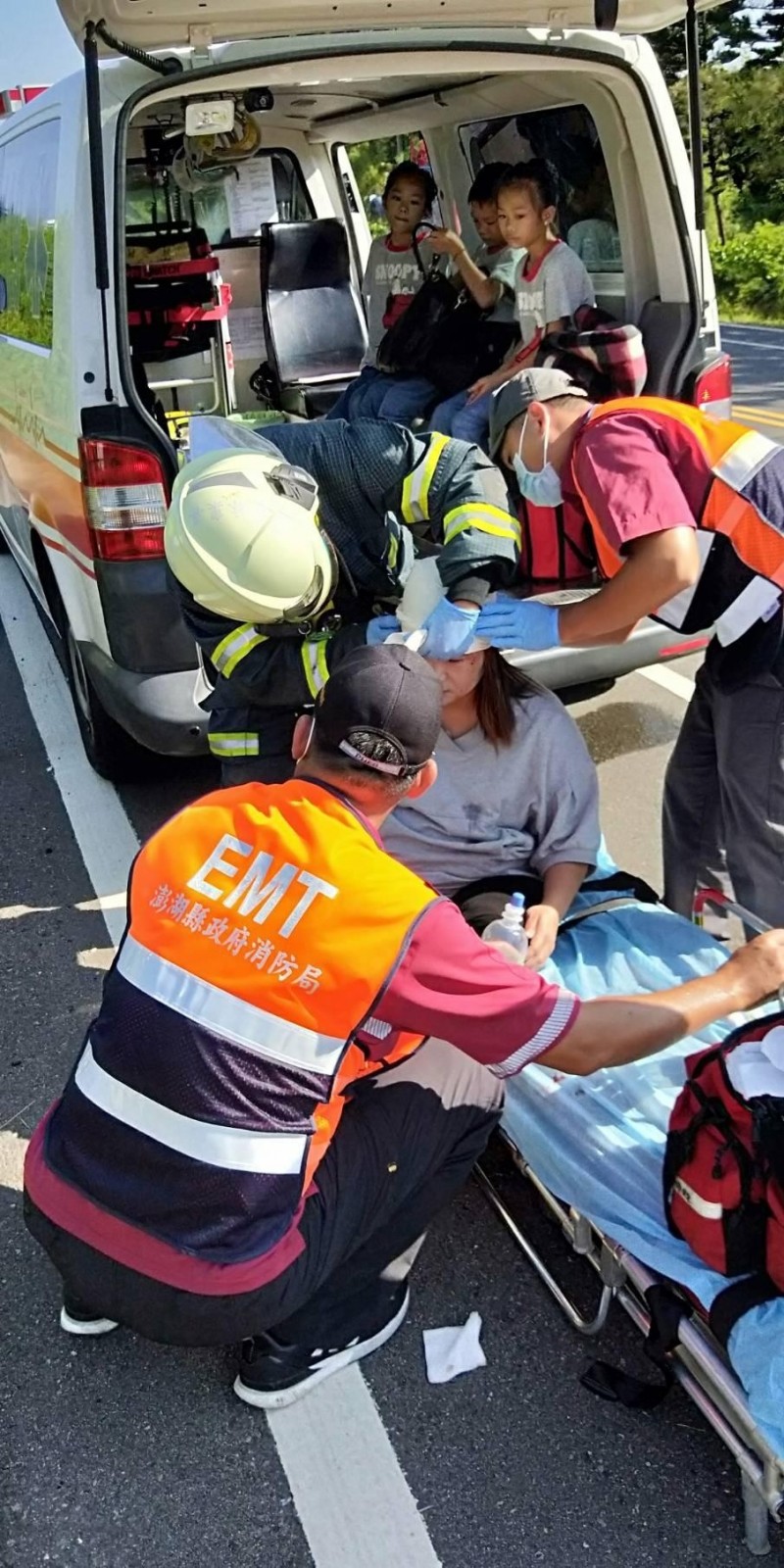 鄭姓女駕駛由消防人員協助脫困，三名女子也坐在救護車等候母親。（澎湖縣消防局提供）