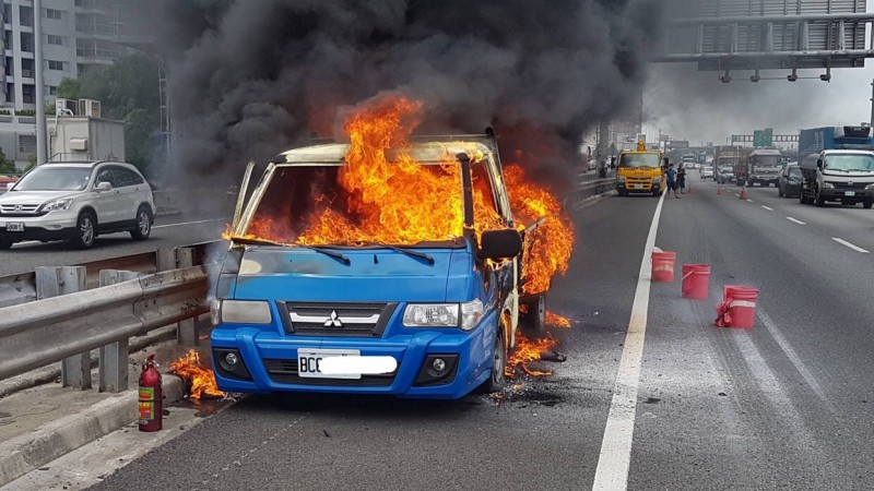 國道1號中壢路段發生火燒車,小貨車秒陷火海,消防人員全力救災。(記者李容萍翻攝) 國道1號中壢路段發生火燒車,小貨車秒陷火海,消防人員全力救災。(記者李容萍翻攝)