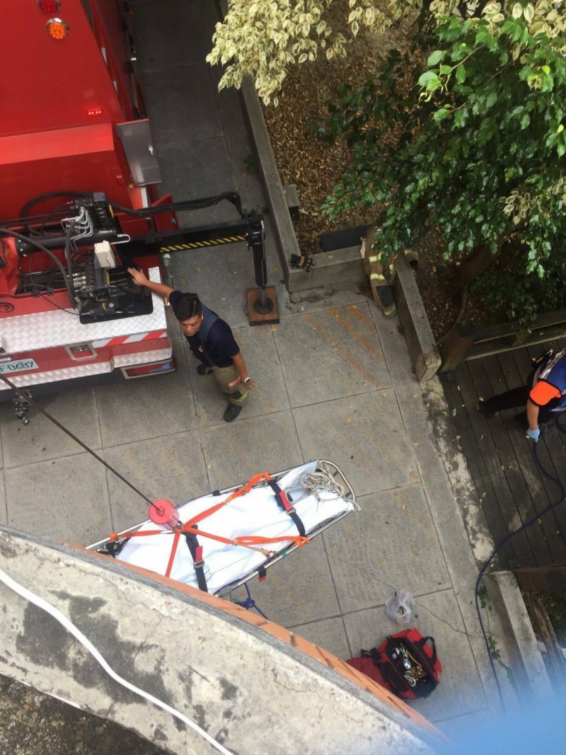 新營消防分隊利用器材車吊臂將墜樓死亡的黃翁吊掛至1樓。（記者楊金城翻攝）