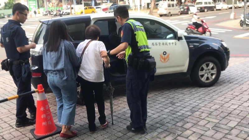 員警哄得老婦（右2）很開心，被指控虐待的女移工（左2）也很貼心，扶老婦搭警車返家。（記者張瑞楨翻攝）