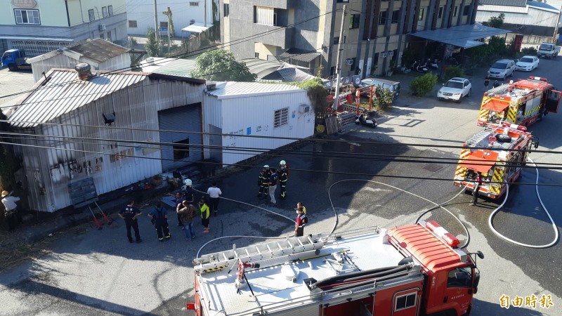 台東市中興陸橋下一棟鐵皮倉庫上午火警，消防人員迅速灌救。（記者黃明堂攝）