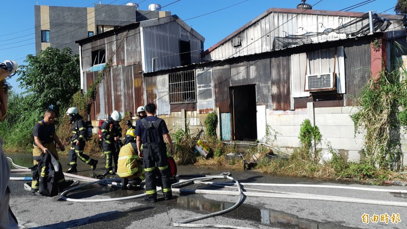 台東市中興陸橋下一棟鐵皮倉庫上午火警，消防人員迅速灌救。（記者黃明堂攝）