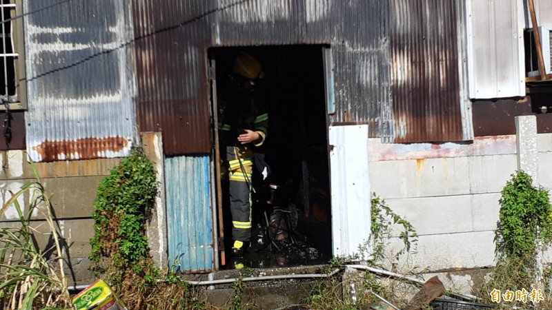 台東市中興陸橋下一棟鐵皮倉庫上午火警，消防人員進入屋內，確認無人員受困。（記者黃明堂攝）