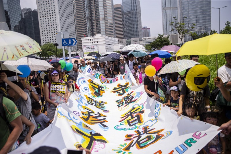 群眾手拉著「守護香港，守護孩子」的大旗，遊行至香港政府總部表達心聲。（歐新社）
