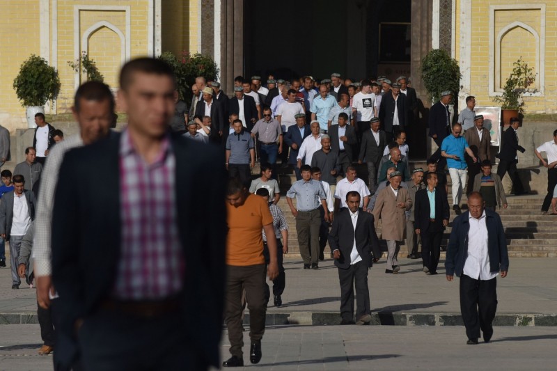 今天是伊斯蘭教的開齋節，但中國政府從2015年開始限制部分新疆穆斯林齋戒月與開齋節活動，陸續破壞清真寺，如今只能低調地到官方允許的清真寺參加禮拜。圖為從清真寺走出的新疆穆斯林。（法新社）