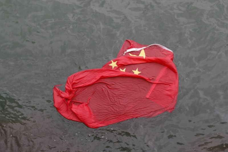 示威民眾將降下的中國國旗拋入海中。（美聯社）