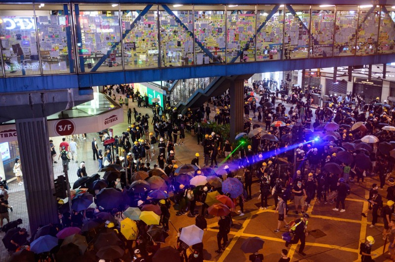 香港抗爭現場因雷射光四散而產生了神奇、科幻般的未來場景，但香港人所必須面對的現實完全不「夢幻」。（法新社）