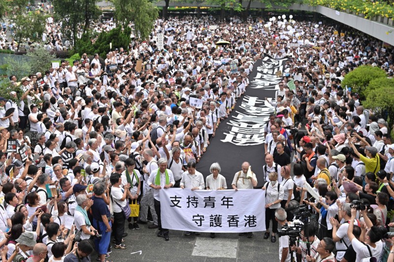 今日香港市民發起的「香港銀髮族靜默遊行」，吸引了上千名銀髮族上街重申五大訴求。（法新社）