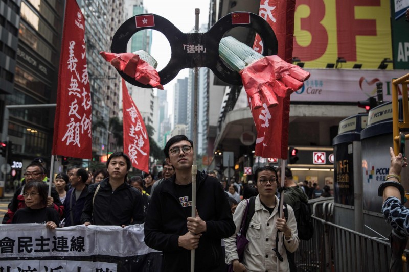 香港政府近期公布《逃犯條例》的草案內容,準備在近期交與香港立法會進行審議;但外界質疑中國當局會藉此「跨境迫害」,透過羅織罪名強迫港府將異議人士移交中國處理。圖為抗議《逃犯條例》修訂的香港人。(法新社) 香港政府近期公布《逃犯條例》的草案內容,準備在近期交與香港立法會進行審議;但外界質疑中國當局會藉此「跨境迫害」,透過羅織罪名強迫港府將異議人士移交中國處理。圖為抗議《逃犯條例》修訂的香港人。(法新社)