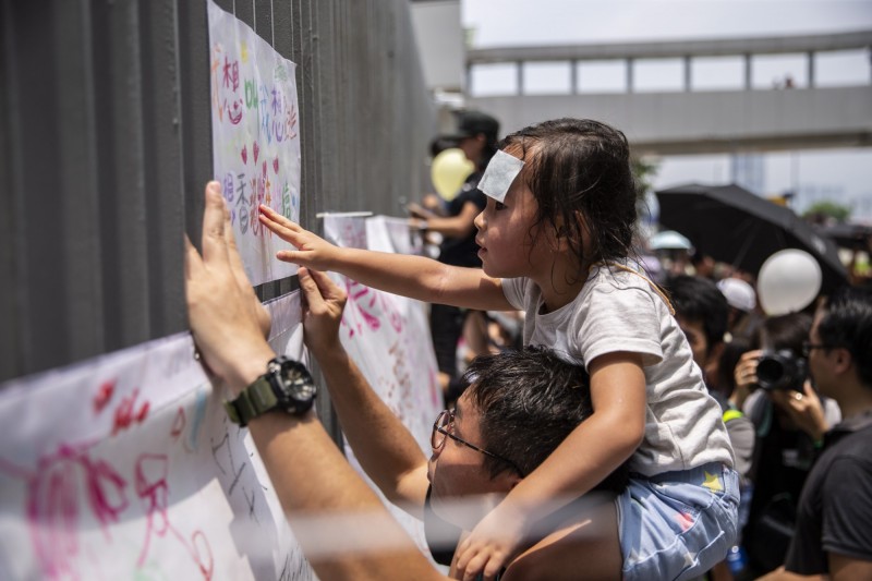 香港民眾發起「反送中」親子遊行，不少爸爸媽媽帶著孩子上街表達意見。（歐新社）