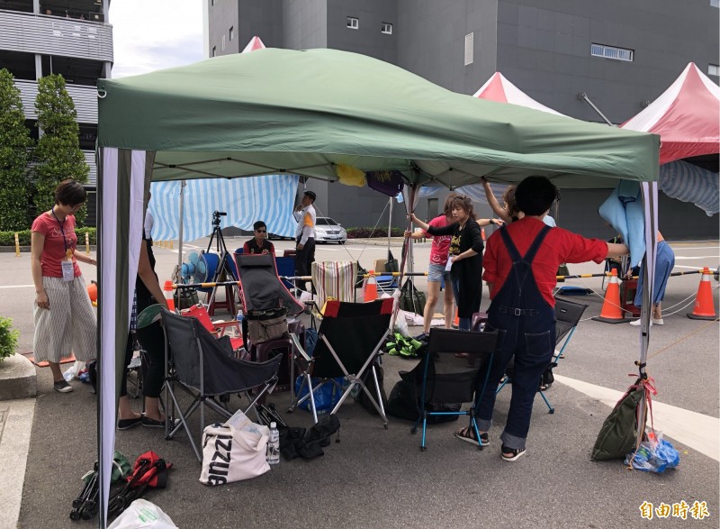 罷工空服員以人身固定支架，以防帳篷被吹翻。（記者魏瑾筠攝）