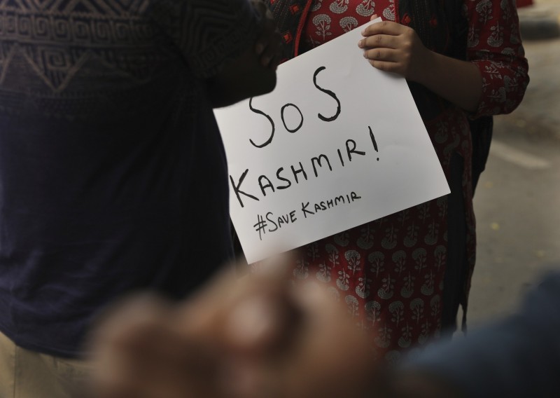 一名學生舉著「拯救喀什米爾」標語，反對印度國會的決定。（美聯社）