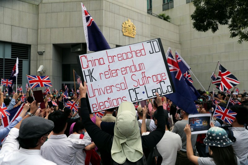 有些人高舉標語，指責中國違反「中英聯合聲明」，並要求香港落實「真普選」。（路透社）