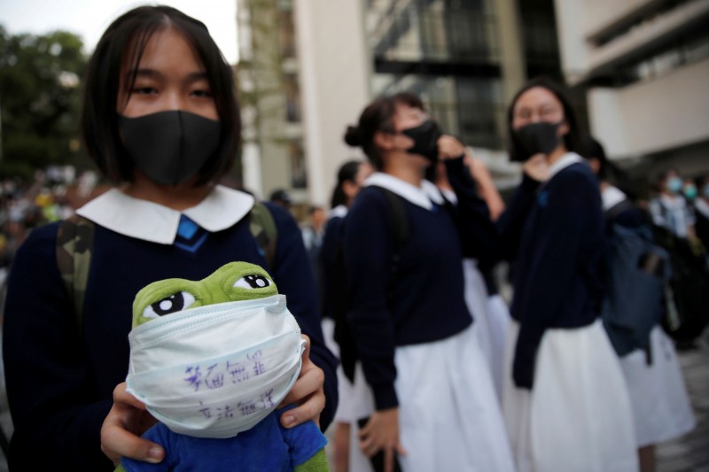 香港中學生18日在港大舉行反警暴集會，學生們戴上口罩，對港警近期濫捕行徑表達不滿。（路透）