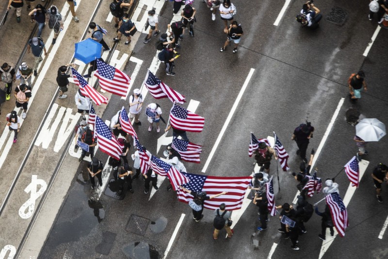 反送中示威者在路上揮舞著美國國旗、高唱美國國歌。（彭博）